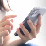 女性のスマホを操作する手元